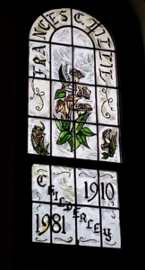 A stained glass window with purple flowers and the words Frances C. Lillie, 1910-1981 Childerley.